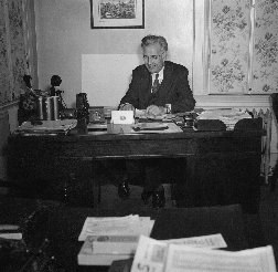 Brother Woodworth in his office. Note: Old style Dictaphone and telephone on desk
